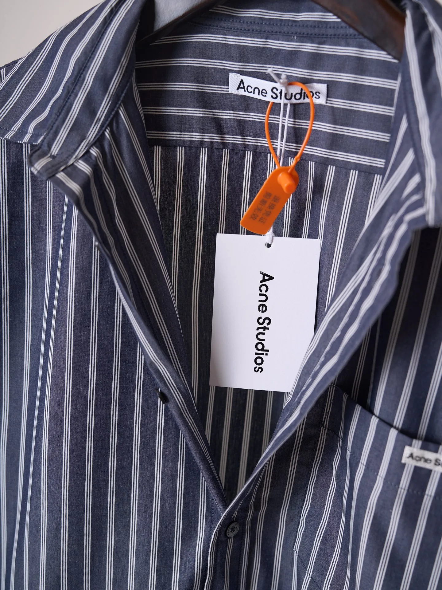 [Real auction] Acne Studios logo double-sleeved striped long-sleeved shirt [In Stock] 44 46 48 50 Customized matte woven combed poplin, crisp and stylish, comfortable and close to the skin, misty charcoal blue interwoven with pure white vertical stripes, between the rising and falling lines, revealing the cool and relaxed style of Scandinavia. Cleverly created layered double-sleeved deconstructed tailoring, breaking the inherent paradigm of traditional shirts, giving the body staggered three-dimensional layers. The iconic stripes of the season are laid out vertically. Rhythm runs through the entire garment. The left chest pocket is embellished with the Acne Studios logo. The brand context is engraved in the square dimensions. The side seams are equipped with wide welt pockets. Integrating styling aesthetics and practical functions. Adhering to the high-end aesthetics of minimalism. Pioneer ingenuity returns to daily life. It interprets the Nordic ready-to-wear attitude of symbiosis of relaxation and sophistication. Infrared positioning cutting machine uses infrared emitters and infrared receivers to achieve precise positioning of materials. The accuracy can reach the micron level. So as to meet the effect of high-precision cutting of plaid alignment. Manual infrared line drawing pockets are assisted by infrared technology to achieve precise positioning and marking of pocket positions, which retains the fineness and flexibility of hand sewing. It adopts side-turning embedded stitching technology to provide high-quality stitching results. Smooth and tidy. The fabrics have been sand washed and have a better hand feel. Not easy to deform, not easy to shrink, not easy to fade, and maintain long-term beauty and loose fit.